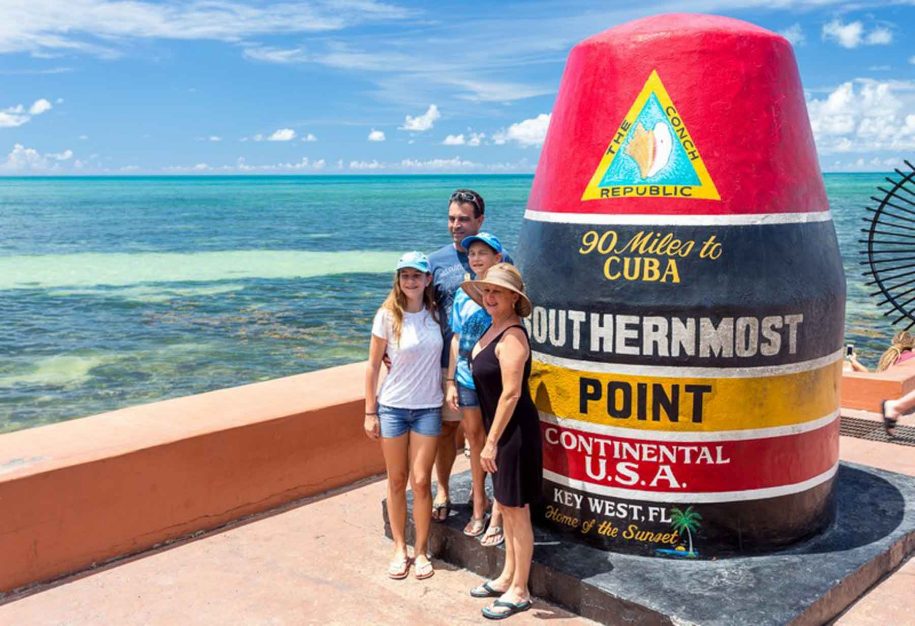 Visitors posing in front of the Southenmost Point Bouy.