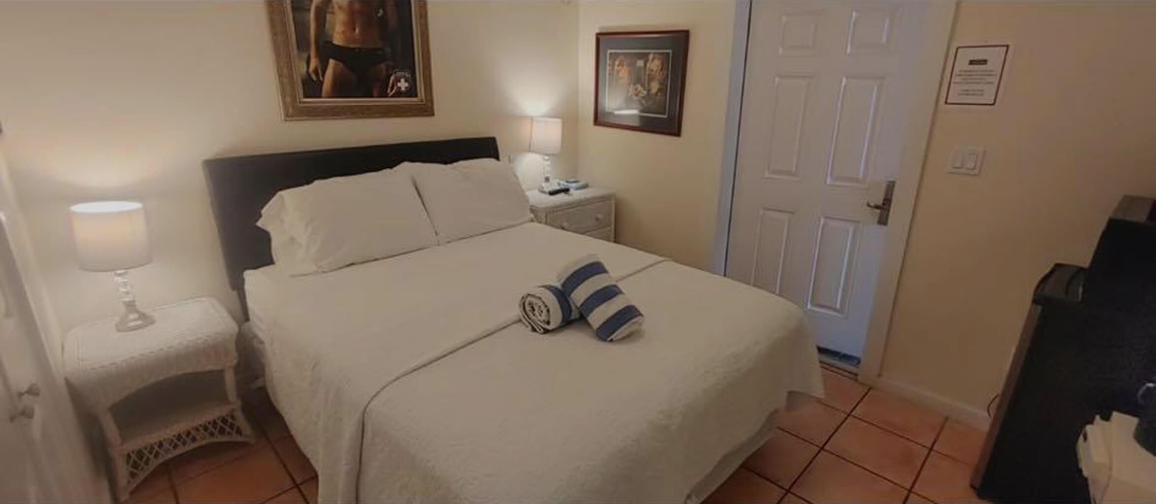 Room 11B, a view of the queen size bed and wicker side dresser.